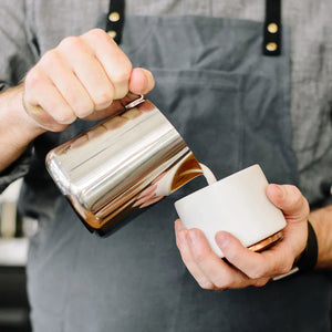 Barista jixxarrab ħalib minn kanna miksija f'azzar inossidabbli, parti mill-Espresso Tillbehör u Mjölkkanna, kollox dwar il-kafè.